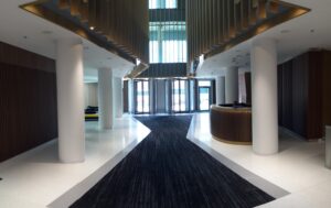 Lobby der Widok Towers in Warschau mit repräsentativem Empfangsbereich, modernem Interior Design und Glasdach – Architektur von TMLC Architects, Architekten Martin Troethan und Clemens Liedermann-Seiss